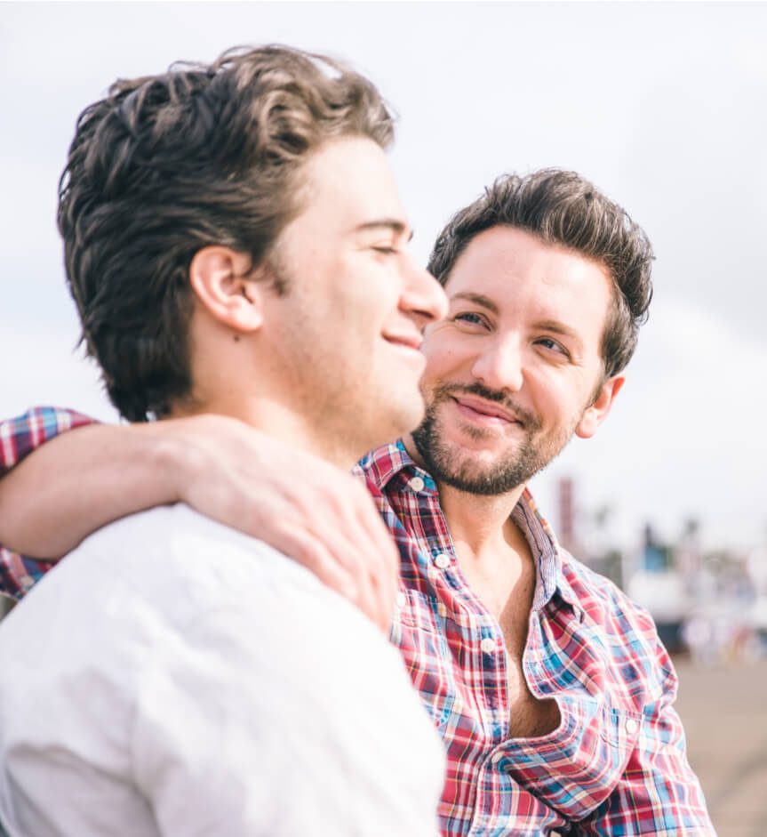 Homosexual couple sitting in Santa monica pier on a bench